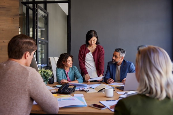 Group of multiethnic businesspeople discussing project details, focusing on data analysis
