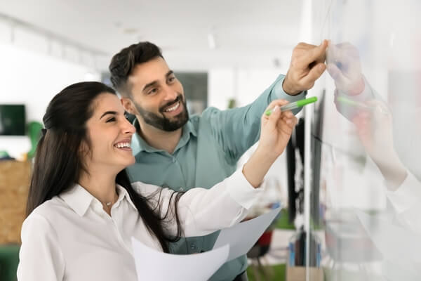 Planning with enthusiasm. Happy smiling 2 diverse marketing team members corporate planning